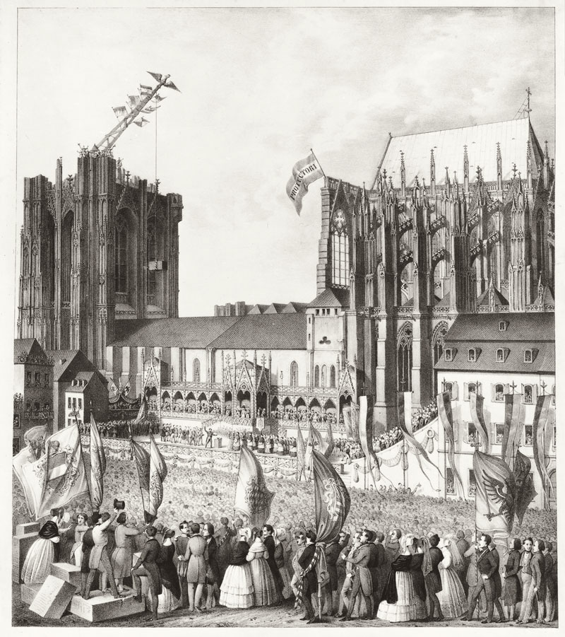 Historische Lithografie der Grundsteinlegung zum Weiterbau des Kölner Doms am 4. September 1842: Eine große Menschenmenge mit Fahnen versammelt sich vor dem unvollendeten Dom mit Südturmstumpf und mittelalterlichem Baukran, am Chor weht eine Fahne mit der Aufschrift „Protectori“.